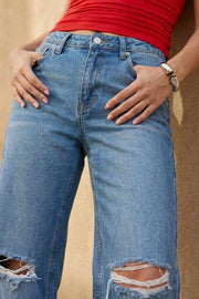 Pantalón wide leg de denim con rotos, tiro alto, bolsillos delanteros y traseros de parche. Cierre con botón y cremallera oculta. Detalle de rotos en bajo.