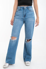 Pantalón wide leg de denim con rotos, tiro alto, bolsillos delanteros y traseros de parche. Cierre con botón y cremallera oculta. Detalle de rotos en bajo.