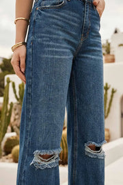 Pantalón wide leg de denim con rotos, tiro alto, bolsillos delanteros y traseros de parche. Cierre con botón y cremallera oculta. Detalle de rotos en bajo.