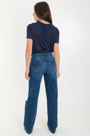Pantalón wide leg de denim con rotos, tiro alto, bolsillos delanteros y traseros de parche. Cierre con botón y cremallera oculta. Detalle de rotos en bajo.