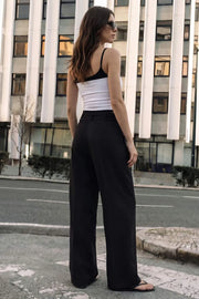 Pantalón de fit wide leg, cintura alta con pretina, trabillas y doble lazo amarrable, pinzas frontales y bolsillos delanteros. Cierre frontal con broche y cremallera ocultos.