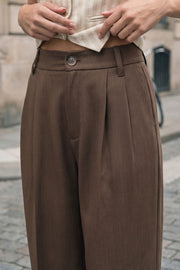 Pantalón de fit wide leg, cintura alta, pretina con detalle v posterior y trabillas, pinzas frontales, bolsillos delanteros y vivos decorativos posteriores. Cierre frontal con botón en contraste y cremallera ocultas.