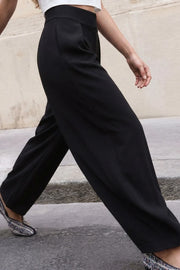 Pantalón wide leg de cintura alta con pretina ancha, pinzas con detalle decorativo frontal, bolsillos delanteros, cierre frontal con broche y cremallera ocultos.