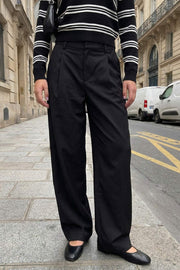Pantalón de fit barrel, pinzas frontales, cintura media con pretina y trabillas, bolsillos delanteros y vivos decorativos posteriores. Cierre frontal con broche y cremallera ocultos.