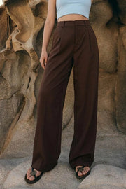 Pantalón de fit barrel, pinzas frontales, cintura media con pretina y trabillas, bolsillos delanteros y vivos decorativos posteriores. Cierre frontal con broche y cremallera ocultos.