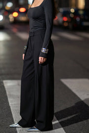 Pantalón wide leg de cintura alta con pretina, pinzas con detalle decorativo frontal, bolsillos delanteros, cierre frontal con broche y cremallera ocultos.