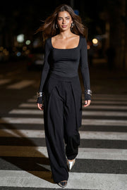 Pantalón wide leg de cintura alta con pretina, pinzas con detalle decorativo frontal, bolsillos delanteros, cierre frontal con broche y cremallera ocultos.
