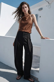Pantalón de fit barrel, pinzas frontales, cintura alta con pretina, bolsillos delanteros, cierre frontal con broche y cremallera ocultos.
