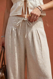 Pantalón de fit balloon, pinzas frontales, cintura alta con pretina elástica y jareta frontal ajustable, bolsillos delanteros y rib elástico en bajo.
