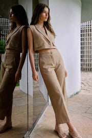 Pantalón de fit amplio, cintura media con pretina, bolsillos delanteros y vivos decorativos posteriores. Detalle de raya frontal y posterior. Cierre frontal con botón y cremallera oculta.