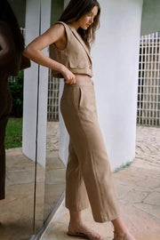 Pantalón de fit amplio, cintura media con pretina, bolsillos delanteros y vivos decorativos posteriores. Detalle de raya frontal y posterior. Cierre frontal con botón y cremallera oculta.