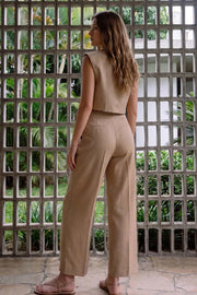 Pantalón de fit amplio, cintura media con pretina, bolsillos delanteros y vivos decorativos posteriores. Detalle de raya frontal y posterior. Cierre frontal con botón y cremallera oculta.
