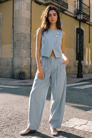 Pantalón de fit balloon, pinzas frontales, cintura alta con pretina, trabillas y cinturón del mismo tejido con hebilla en contraste, bolsillos delanteros, cierre frontal con broche y cremallera ocultos.