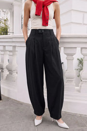 Pantalón fit balloon, cintura alta con pretina elástica posterior y trabillas, bolsillos delanteros, pinzas frontales, cierre frontal con botones y cremallera oculta.