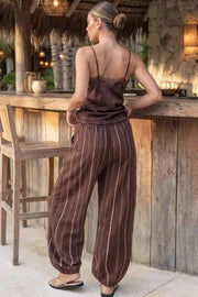 Pantalón de fit balloon, estampado rayas, pinzas con cortes frontales, cintura alta con pretina elástica y jareta frontal ajustable, bolsillos delanteros, pinzas y elástico en bajo.
