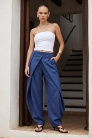 Pantalón fit barrel de cintura media, cruce doble decorativo con pretina y trabillas, pinzas frontales y vivos decorativos posteriores. Cierre frontal con broche y cremallera ocultos.