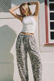 Pantalón fit barrel de estampado paisleys, cintura media con pretina elástica y jareta frontal ajustable.