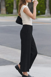 Pantalón de fit culotte, cintura alta con pretina, raya frontal y posterior, bolsillos delanteros y vivos decorativos posteriores. Cierre frontal con broche y cremallera ocultos.