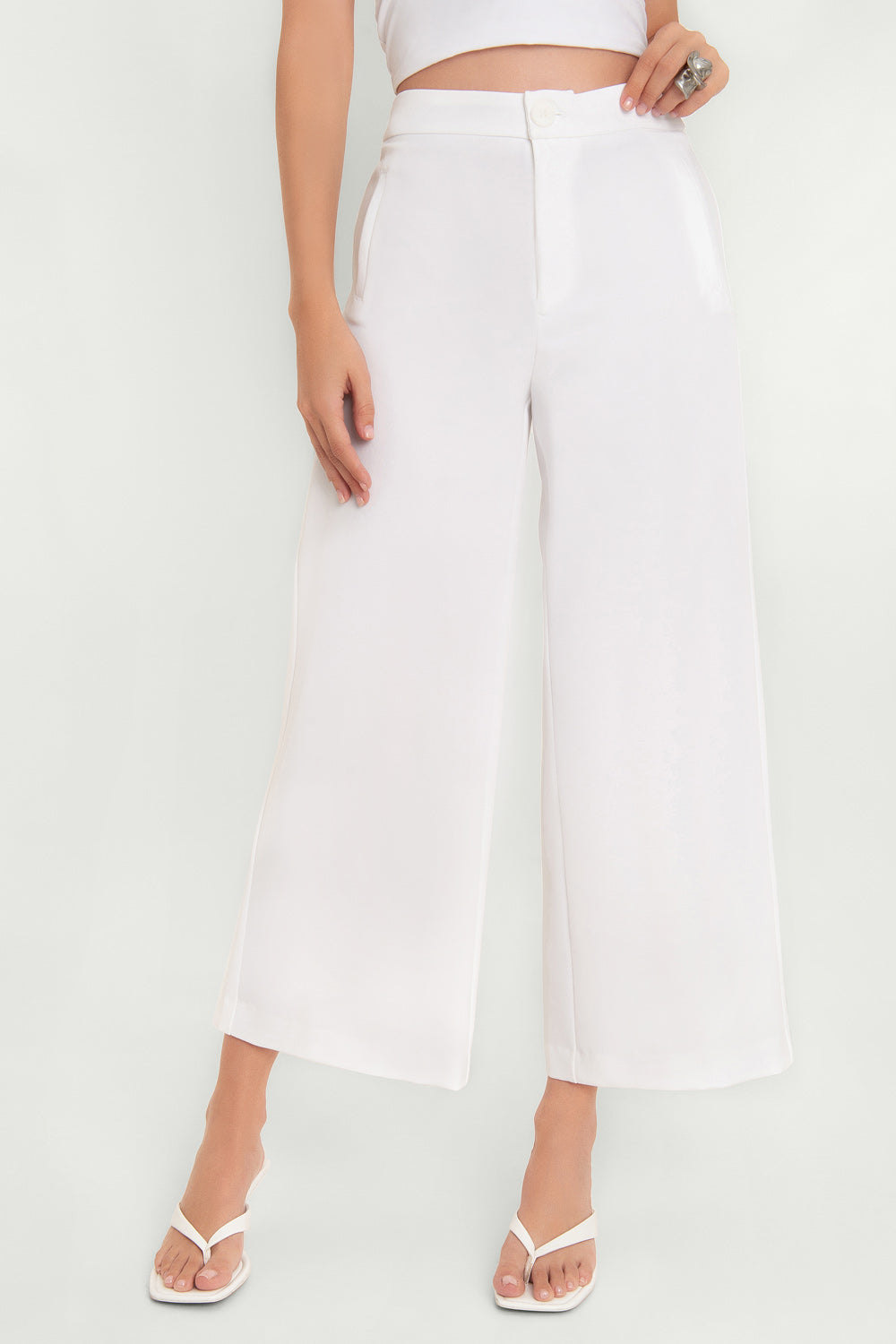 Pantalón de fit culotte, cintura alta con pretina, vivos decorativos delanteros y cierre frontal con cremallera oculta y botón.