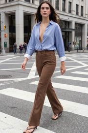 Pantalón ajustado de fit flare, cintura alta con pretina y trabillas, raya frontal y posterior, cierre con cremallera oculta y botones.