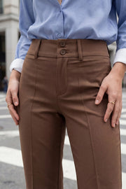 Pantalón ajustado de fit flare, cintura alta con pretina y trabillas, raya frontal y posterior, cierre con cremallera oculta y botones.