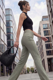 Pantalón ajustado de fit flare, cintura alta con pretina y trabillas, raya frontal y posterior, cierre con cremallera oculta y botones.