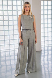 Pantalón de fit palazzo, cintura alta con pretina elástica, bolsillos delanteros y pinzas frontales.