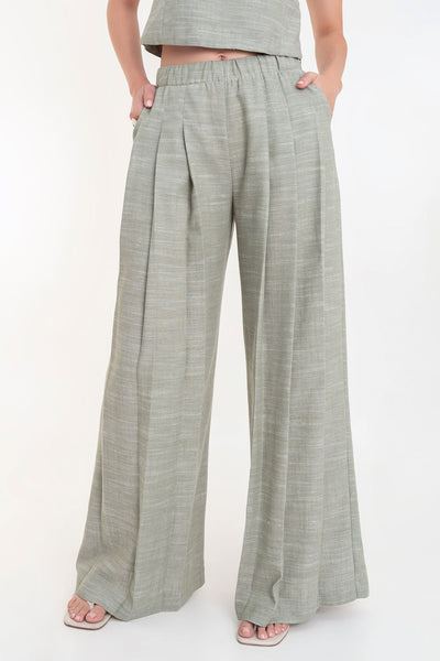 Pantalón de fit palazzo, cintura alta con pretina elástica, bolsillos delanteros y pinzas frontales.