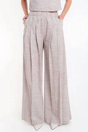 Pantalón de fit palazzo, cintura alta con pretina elástica, bolsillos delanteros y pinzas frontales.