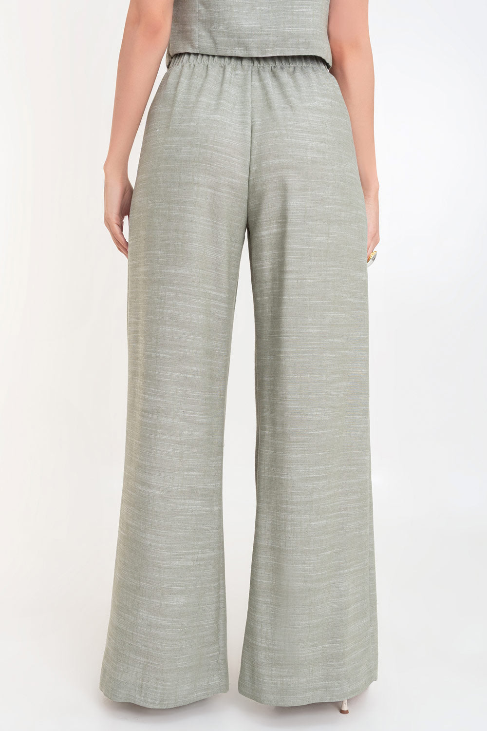 Pantalón de fit palazzo, cintura alta con pretina elástica, bolsillos delanteros y pinzas frontales.