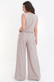 Pantalón de fit palazzo, cintura alta con pretina elástica, bolsillos delanteros y pinzas frontales.