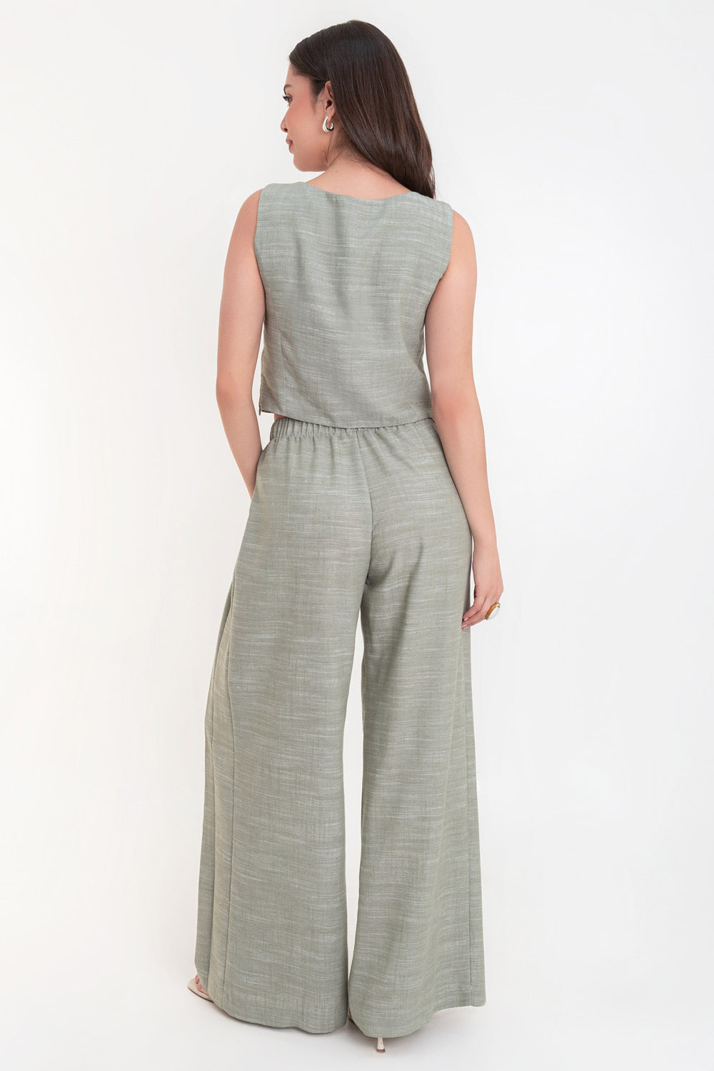 Pantalón de fit palazzo, cintura alta con pretina elástica, bolsillos delanteros y pinzas frontales.