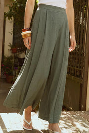 Pantalón de fit wide leg, pinzas frontales, cintura alta con pretina y cruce frontal decorativo. Cierre lateral con cremallera oculta.