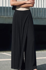 Pantalón de fit wide leg, pinzas frontales, cintura alta con pretina y cruce frontal decorativo. Cierre lateral con cremallera oculta.