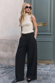 Pantalón de fit palazzo, cintura alta, pinzas frontales y cierre posterior con cremallera oculta.