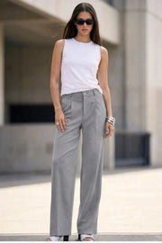 Pantalón de fit recto, cintura alta con pretina y trabillas, bolsillos delanteros y vivos decorativos posteriores, pinzas frontales. Cierre con botón y cremallera oculta.