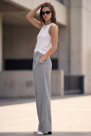 Pantalón de fit recto, cintura alta con pretina y trabillas, bolsillos delanteros y vivos decorativos posteriores, pinzas frontales. Cierre con botón y cremallera oculta.