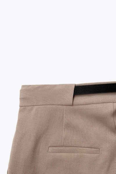 Pantalón de fit recto, cintura alta con pretina y trabilla ancha, bolsillos delanteros y vivos decorativos posteriores. Cierre frontal con broche y cremallera ocultos. Detalle de cinturón con hebilla en contraste.