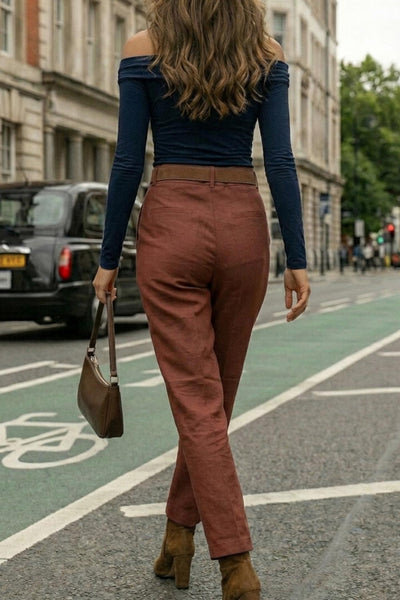 Pantalón de fit recto, cintura alta con pretina y trabillas, bolsillos delanteros y vivos decorativos posteriores. Detalle de raya frontal y posterior, cinturón con hebilla en contraste, cierre frontal con broche y cremallera ocultos.