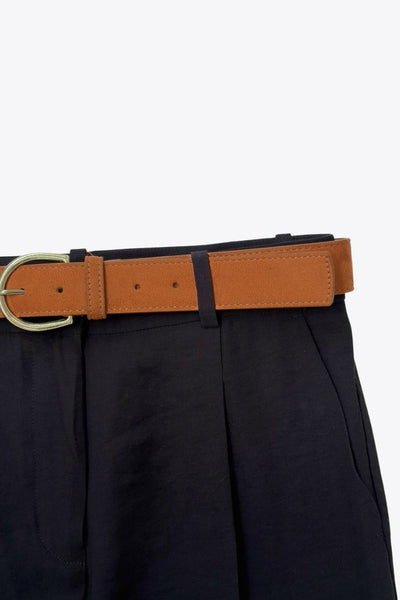 Pantalón de fit recto, cintura alta con pretina y trabillas, bolsillos delanteros y vivos decorativos posteriores. Detalle de raya frontal y posterior, cinturón con hebilla en contraste, cierre frontal con broche y cremallera ocultos.