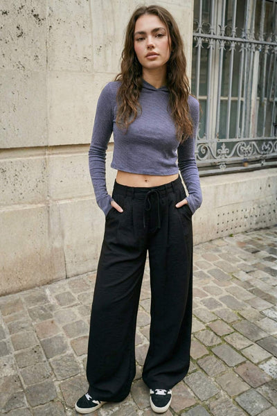 Pantalón de fit recto, pinzas frontales, cintura alta con pretina y trabillas, bolsillos delanteros, vivo decorativo posterior, cierre frontal con broche y cremallera ocultos. Detalle de jareta frontal ajustable en cintura.