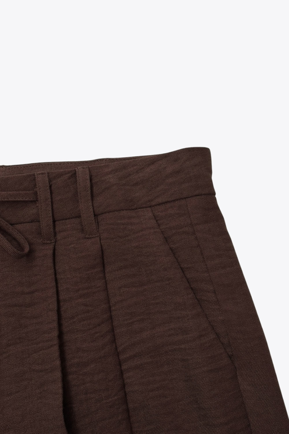 Pantalón de fit recto, pinzas frontales, cintura alta con pretina y trabillas, bolsillos delanteros, vivo decorativo posterior, cierre frontal con broche y cremallera ocultos. Detalle de jareta frontal ajustable en cintura.