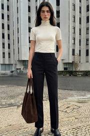 Pantalón básico de fit recto, cintura alta con pretina elástica posterior, raya frontal y posterior, cierre con broche y cremallera ocultos.