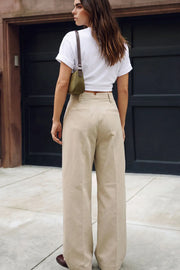 Pantalón de fit wide leg, cintura alta con pretina con detalle v posterior y trabillas, pinzas frontales, bolsillos delanteros, vivos decorativos posteriores, cierre frontal con botón en contraste y cremallera oculta.