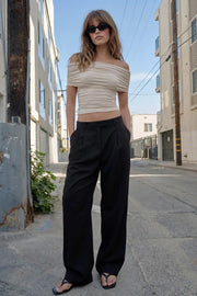 Pantalón de fit wide leg, cintura alta con pretina y trabillas, pinzas frontales con raya frontal, bolsillos delanteros, vivo decorativo posterior, cierre frontal con broche y cremallera ocultos.