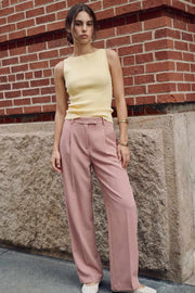 Pantalón de fit wide leg, cintura alta con pretina y trabillas, pinzas frontales con raya frontal, bolsillos delanteros, vivo decorativo posterior, cierre frontal con broche y cremallera ocultos.