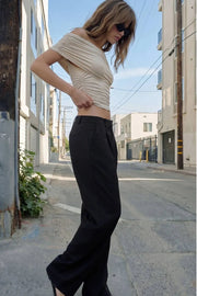 Pantalón de fit wide leg, cintura alta con pretina y trabillas, pinzas frontales con raya frontal, bolsillos delanteros, vivo decorativo posterior, cierre frontal con broche y cremallera ocultos.