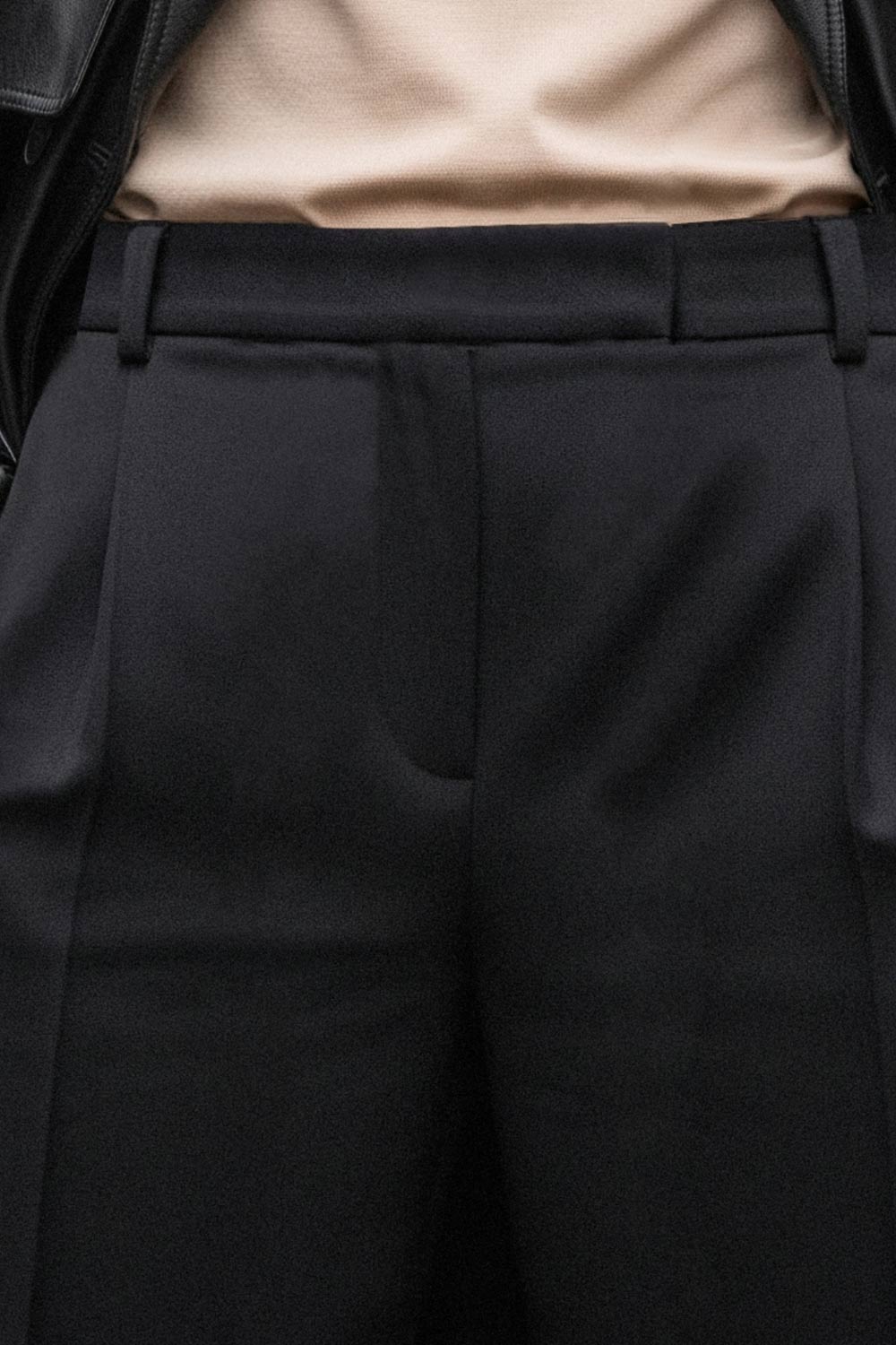 Pantalón de fit wide leg, cintura alta con pretina y trabillas, pinzas frontales con raya frontal, bolsillos delanteros, vivo decorativo posterior, cierre frontal con broche y cremallera ocultos.