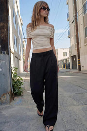 Pantalón de fit wide leg, cintura alta con pretina y trabillas, pinzas frontales con raya frontal, bolsillos delanteros, vivo decorativo posterior, cierre frontal con broche y cremallera ocultos.