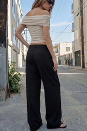 Pantalón de fit wide leg, cintura alta con pretina y trabillas, pinzas frontales con raya frontal, bolsillos delanteros, vivo decorativo posterior, cierre frontal con broche y cremallera ocultos.